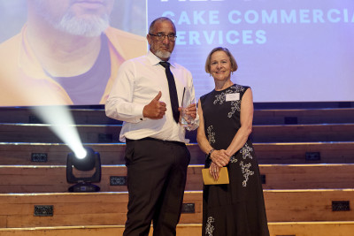 Image of Lee onstage with his award