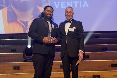 Naki standing onstage with his award. 