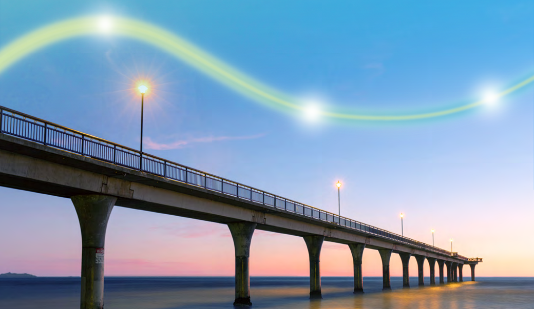 A bridge at sunrise with a lightpath drawn above